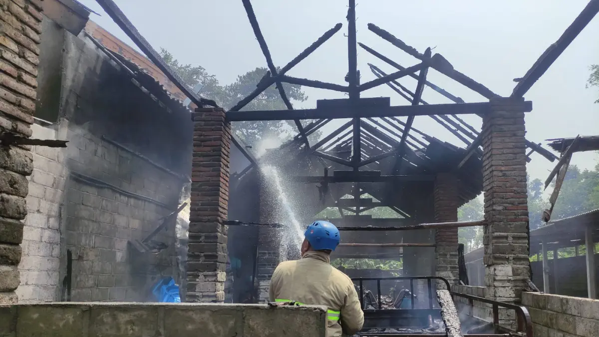 Petugas Damkar Kabupaten Blitar memadamkan api yang membakar gudang pakan bebek di Desa Ringinanyar, Kecamatan Ponggok, Rabu (19/8). Kebakaran diduga dipicu pembakaran sampah klobot dan janggel jagung di dekat gudang.