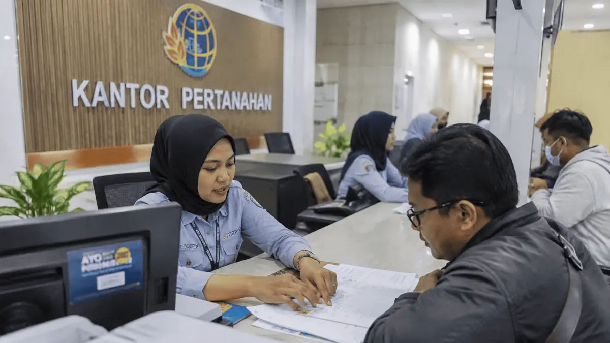 Petugas Kantor Pertanahan melayani masyarakat yang mengurus pendaftaran tanah pertama kali dengan memeriksa kelengkapan dokumen sebelum proses pengukuran dilakukan.