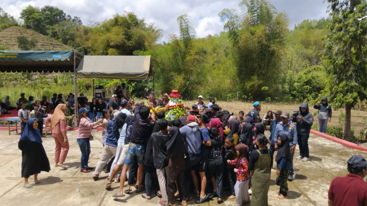 Agus muhaimin/radar blitar
Warga tampak antusias menangkap air sisa jamasan kiai bonto dari panggung.
