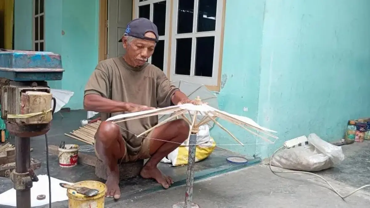 EXSIS : Asbani merakit payung kertas yang sudah ditekuni sejak puluhan tahun di rumahnya.