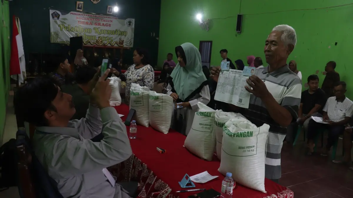 FAJAR RAHMAD AW/RADAR BLITAR
JATAH TIGA BULAN: Warga Desa Sragi, Kecamatan Talun menerima bantuan pangan berupa beras sebanyak 30 kg, kemarin (2/9). 