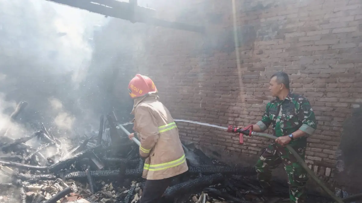 BEKERJA KERAS: Petugas gabungan berusaha memadamkan sisa kobaran api di rumah milik Darmiati pada Senin (14/9) pagi.