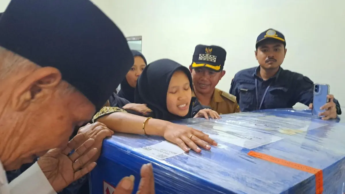 BERDUKA : Istri Reynar Fausta Yosillianto memeluk peti jenazah suaminya sebelum dimakamkan