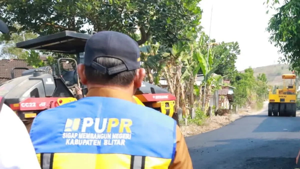 Petugas Dinas PUPR Kabupaten Blitar memantau proses pengaspalan jalan menggunakan alat berat di salah satu ruas jalan. Pengerjaan infrastruktur tersebut menjadi bagian dari percepatan proyek strategis daerah (PSD) yang ditargetkan tuntas sebelum akhir tahun.