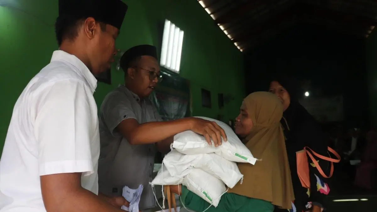 GENCARKAN AGEN PERLINSOS : Seorang warga meneriman bantuan berupa beras.