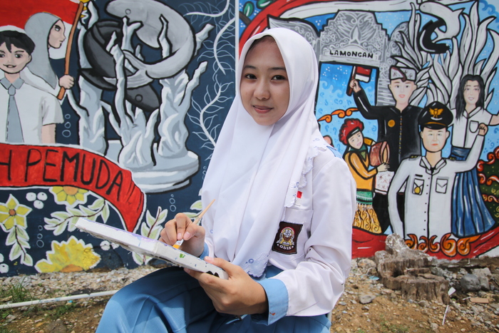 INGIN TERUS BERKEMBANG: Anatasya N.F dengan karya mural yang dikerja an bersama Thania S.A, Najla B.R, Rheyna Q.B, dan Evelyn M.A. yang meraih juara 1 festival mural Wake Up 2023.