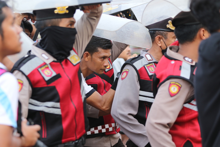 Berlindung - Wasit Amri Nurhadi yang memimpin laga Persela Vs Persipa Pati berlindung diantara petugas  keamanan usai laga berakhir untuk kemenangan Persipa (Anjar. / Radar Lamongan)