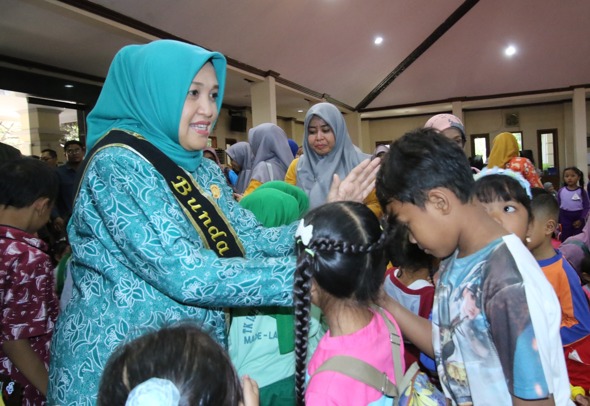 SAYANG ANAK: Bunda PAUD Lamongan, Anis Yuhronur Efendi, menyalami anak - anak yang ada di Pendopo Lokatantra. (ANJAR DWI PRADIPTA/RDR.LMG)