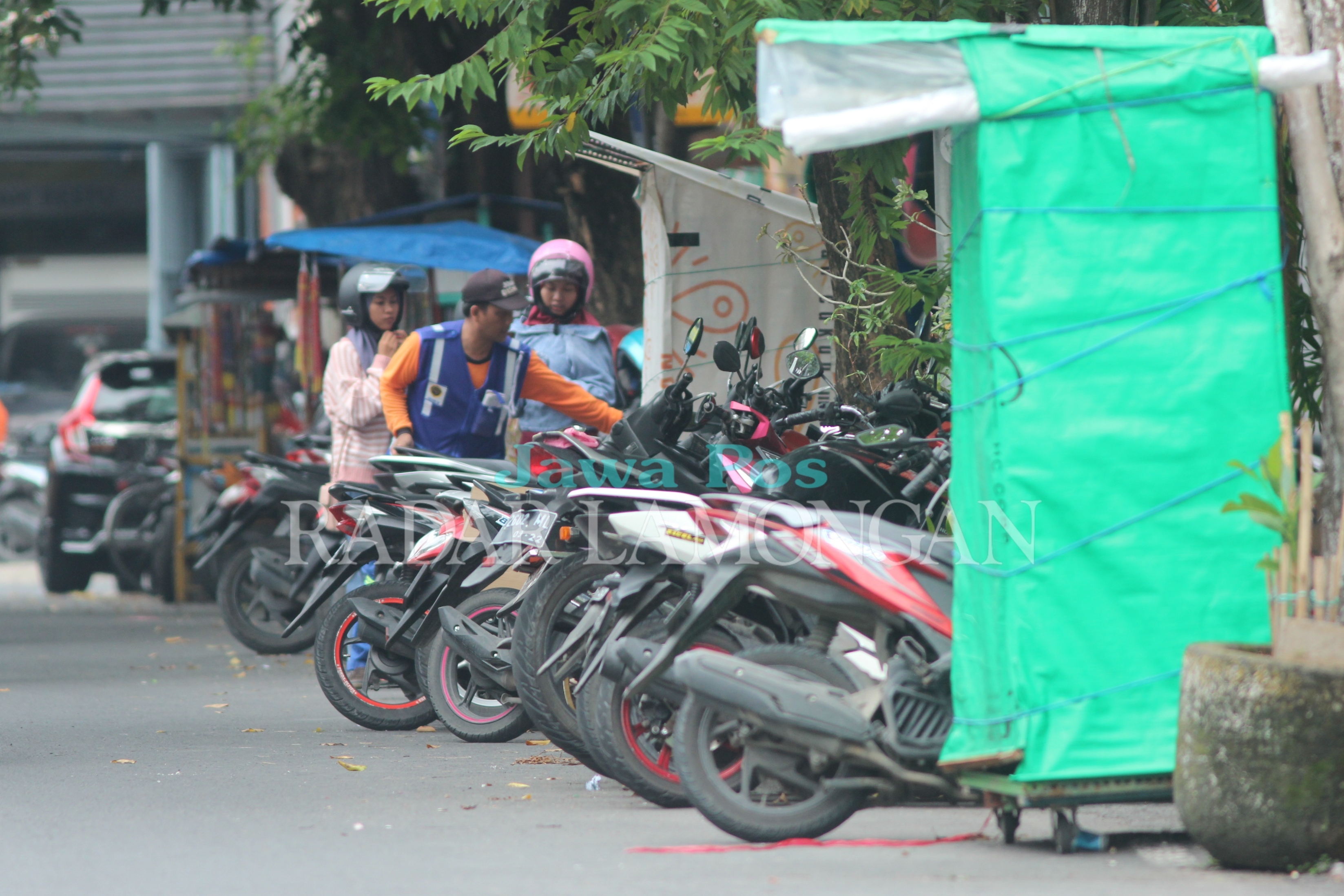 MENDAPAT SOROTAN: Jukir kerap meminta uang kepada masyarakat di area parkir berlangganan. (FOTO : Anjar. / Radar Lamongan)