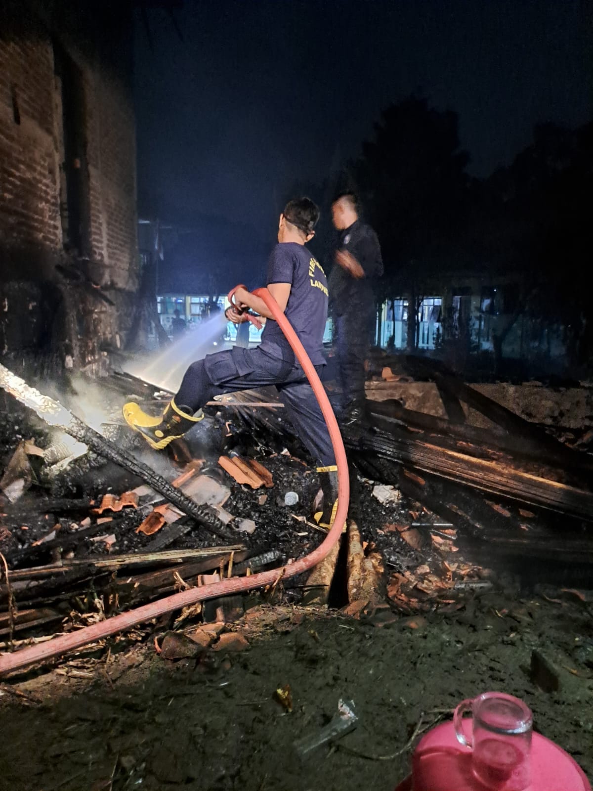 MUDAH TERBAKAR: Petugas pemadam kebakaran saat berupaya memadamkan api di kandang milik warga Desa Gempolmanis, Kecamatan Sambeng. (Ist. / Radar Lamongan)