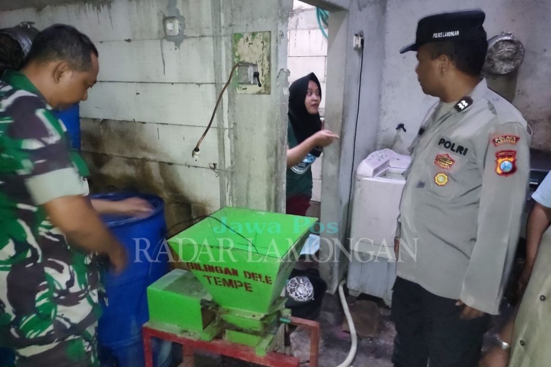 TINJAU TKP: Petugas kepolisian saat berada di lokasi meninggalnya dua pasutri setelah tersengat aliran listrik. (Ist. / Radar Lamongan)