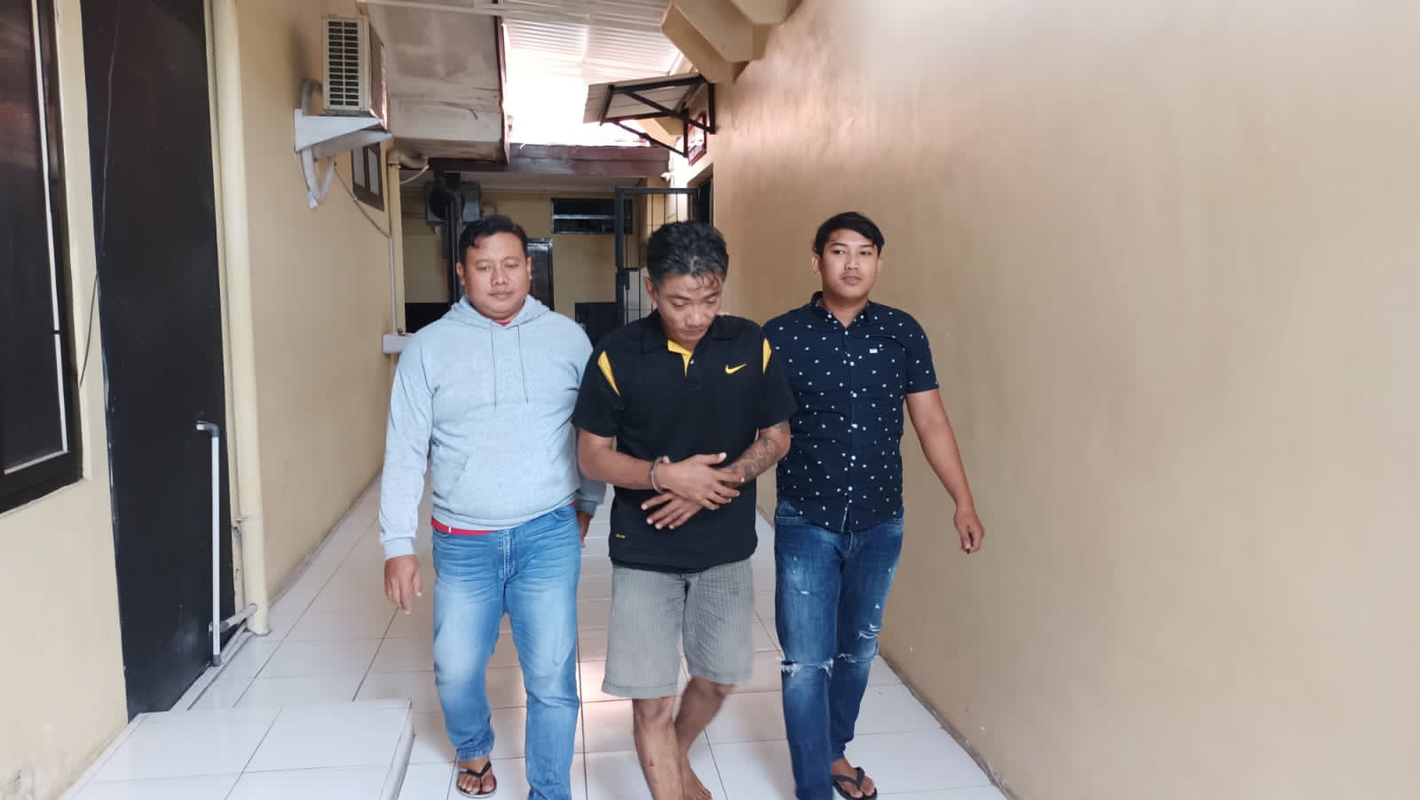 RESIDIVIS: Khoirul Huda dikawal dua anggota Polres Lamongan. (IST/RDR.LMG)