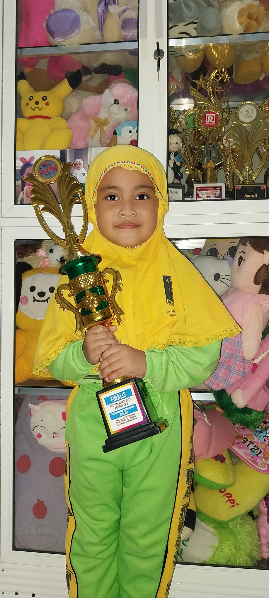 SUKA MENEMPEL STIKER: Nakeisha Adzkiya Maheswari membawa piala finalis Festival Kolase 2023. (IST/RDR.LMG)