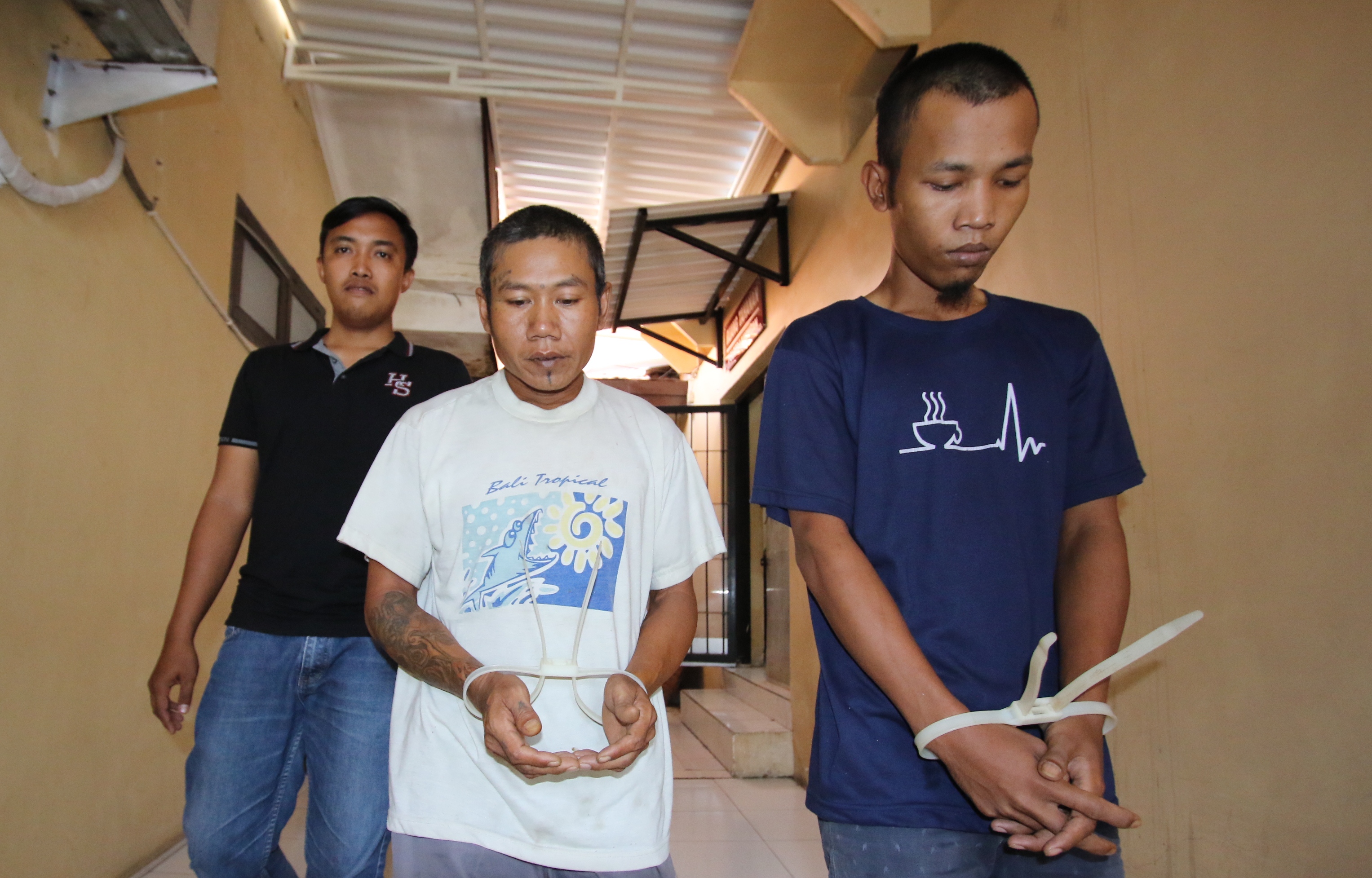 SEMBILAN KALI MENCURI: Dua tersangka pencurian motor dikawal petugas Polres Lamongan Kamis (25/1). (ANJAR DWI PRADIPTA/RDR.LMG)