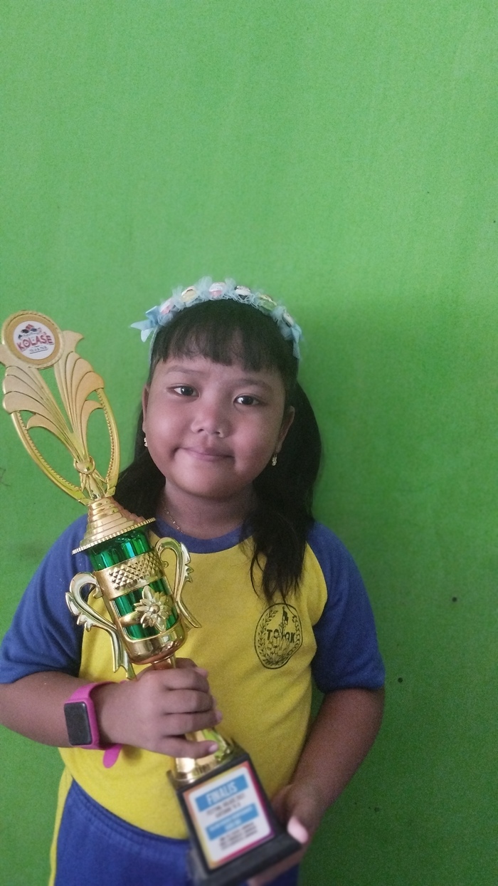 SUKA SPONGE BOB DAN UPIN IPIN: Afika Putri Ramadhani membawa piala Festival Kolase 2023. (IST/RDR.LMG)