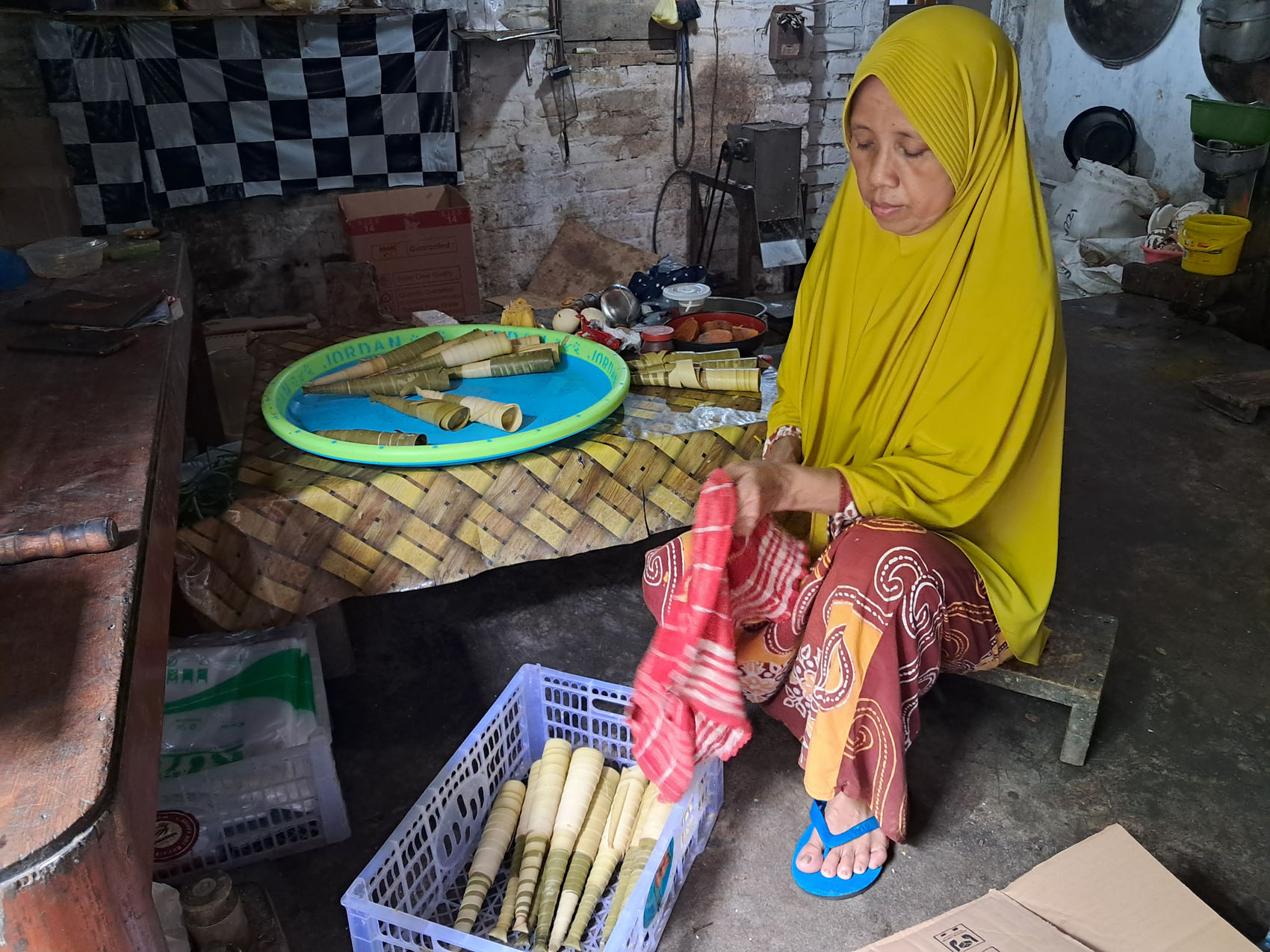 TURUN TEMURUN: Umu Nazidah membersihkan lontar untuk dijadikan pembungkus jumbreg sebelum direbus. (GAMAL A/RDR.LMG)