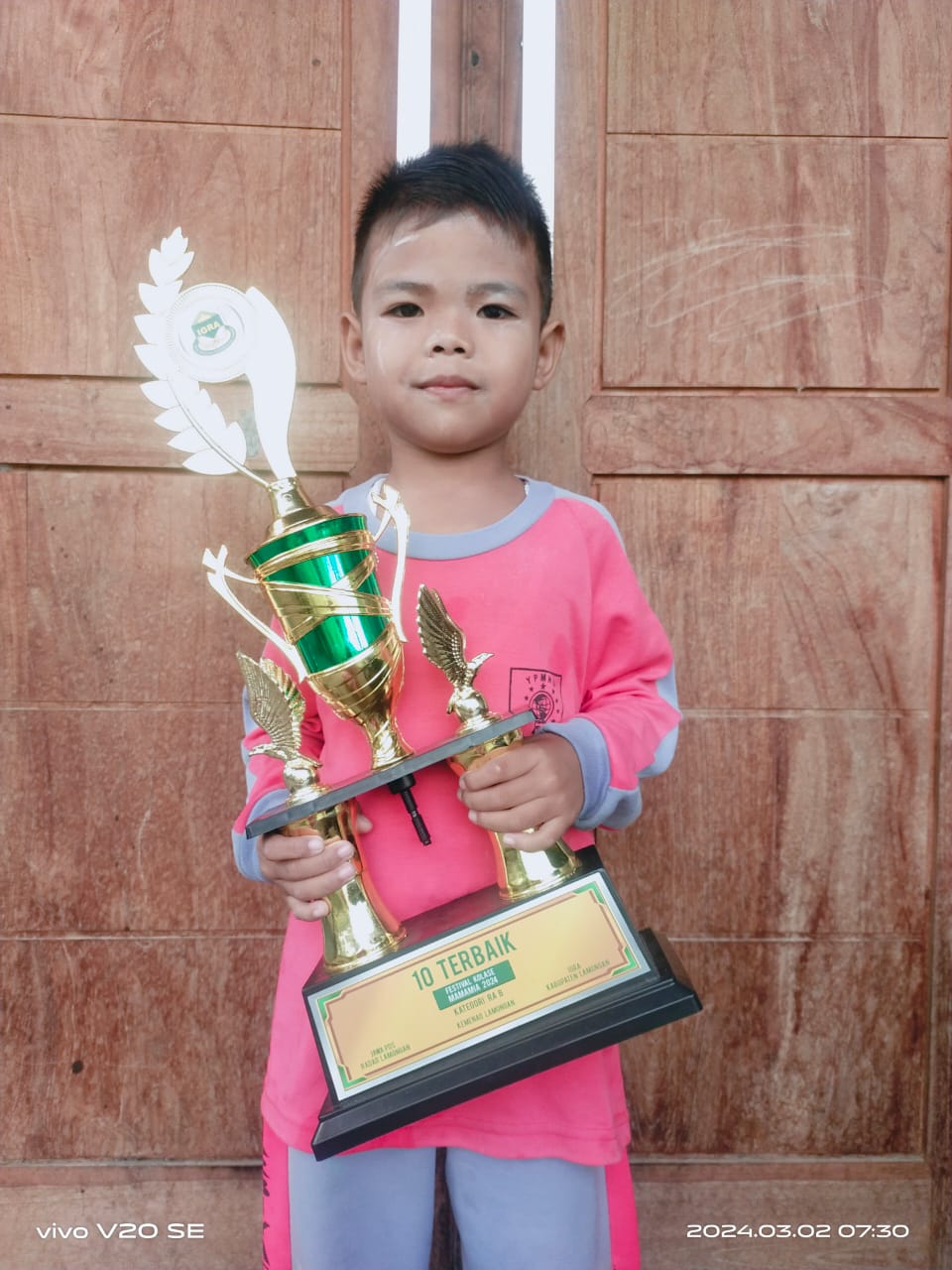 SUKA KUCING: Maulana Setiyawan Al Khaffi membawa piala sepuluh terbaik Festival Kolase Mamamia 2024. (IST/RDR.LMG)