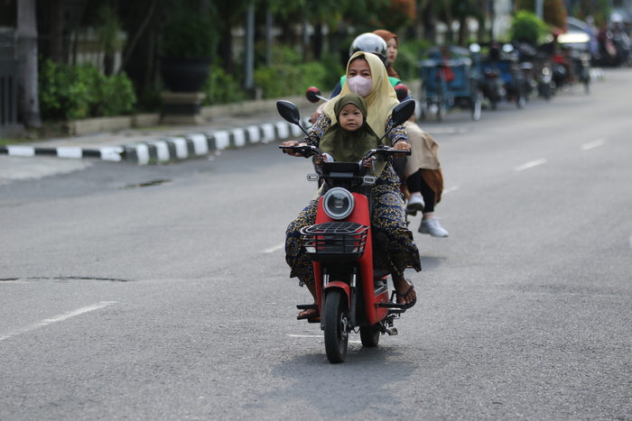 DI JALAN TANPA HELM: Pengendara sepeda listrik yang melintas di jalan protokol. (ANJAR DWI PRADIPTA/RADAR LAMONGAN)