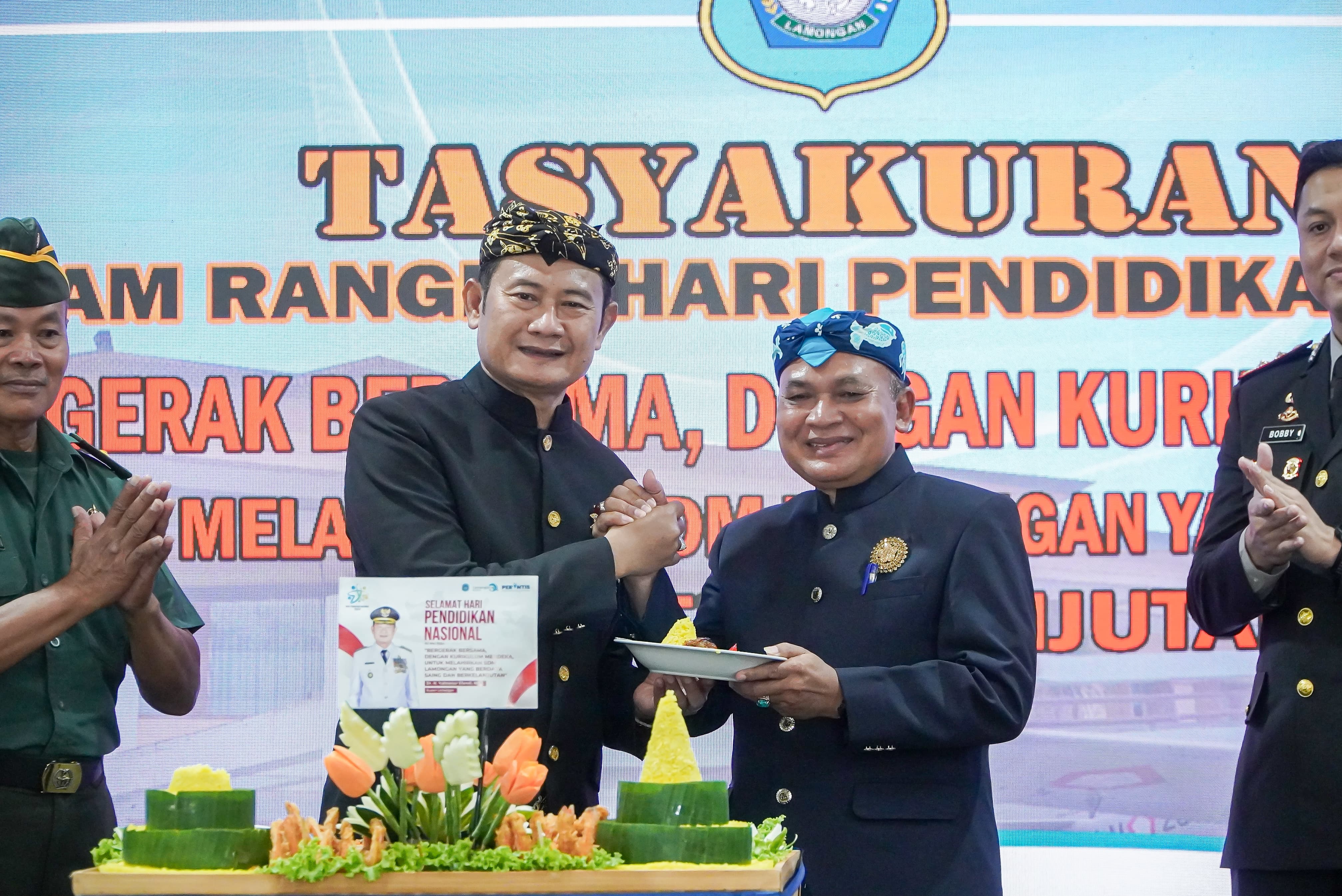 MAJU TERUS PENDIDIKAN LAMONGAN: Bupati Lamongan, Dr H Yuhronur Efendi, MBA, M.Ek memberikan potongan tumpeng dalam syukuran Hardiknas kepada Kepala Dinas Pendidikan Lamongan Ir. Munif Syarif, MM.(IST)