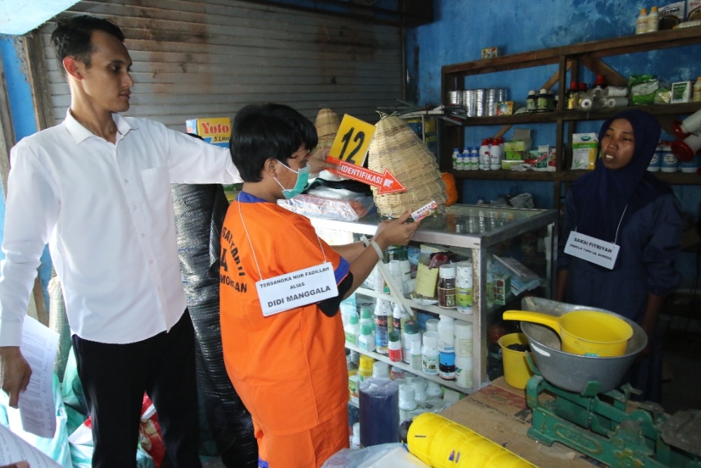 TERENCANA: Salah satu rekonstruksi menunjukkan saat tersangka Nur Fadillah membeli racun tikus di salah satu toko pertanian yang digunakan untuk meracuni Abdul Aziz.&nbsp;(Anjar. / Radar Lamongan)