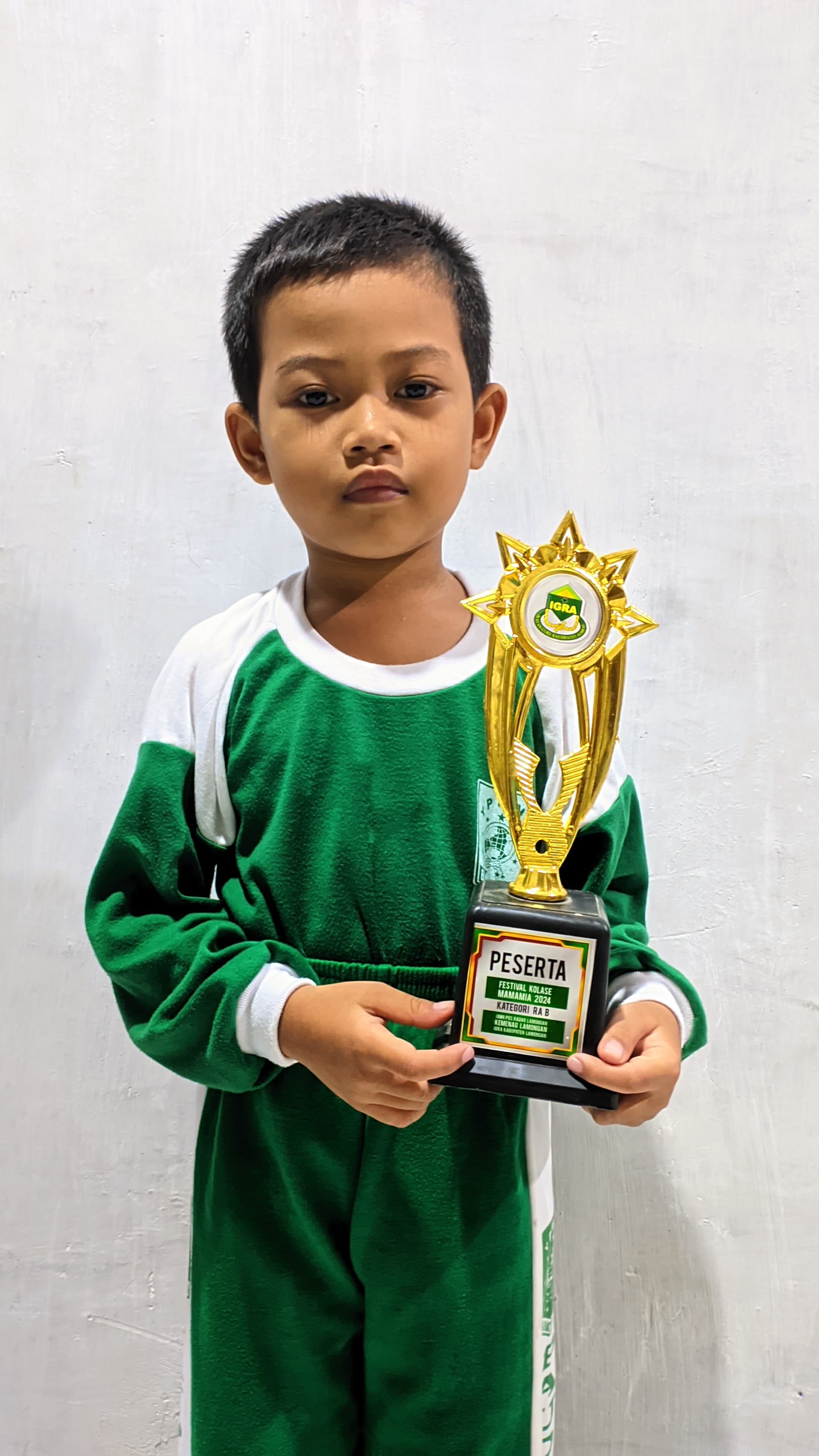 BISA BERSEPATU RODA: Leofardo Ardiansyah membawa piala finalis Festival Kolase Mamamia 2024. (ISTIMEWA/RADAR LAMONGAN)