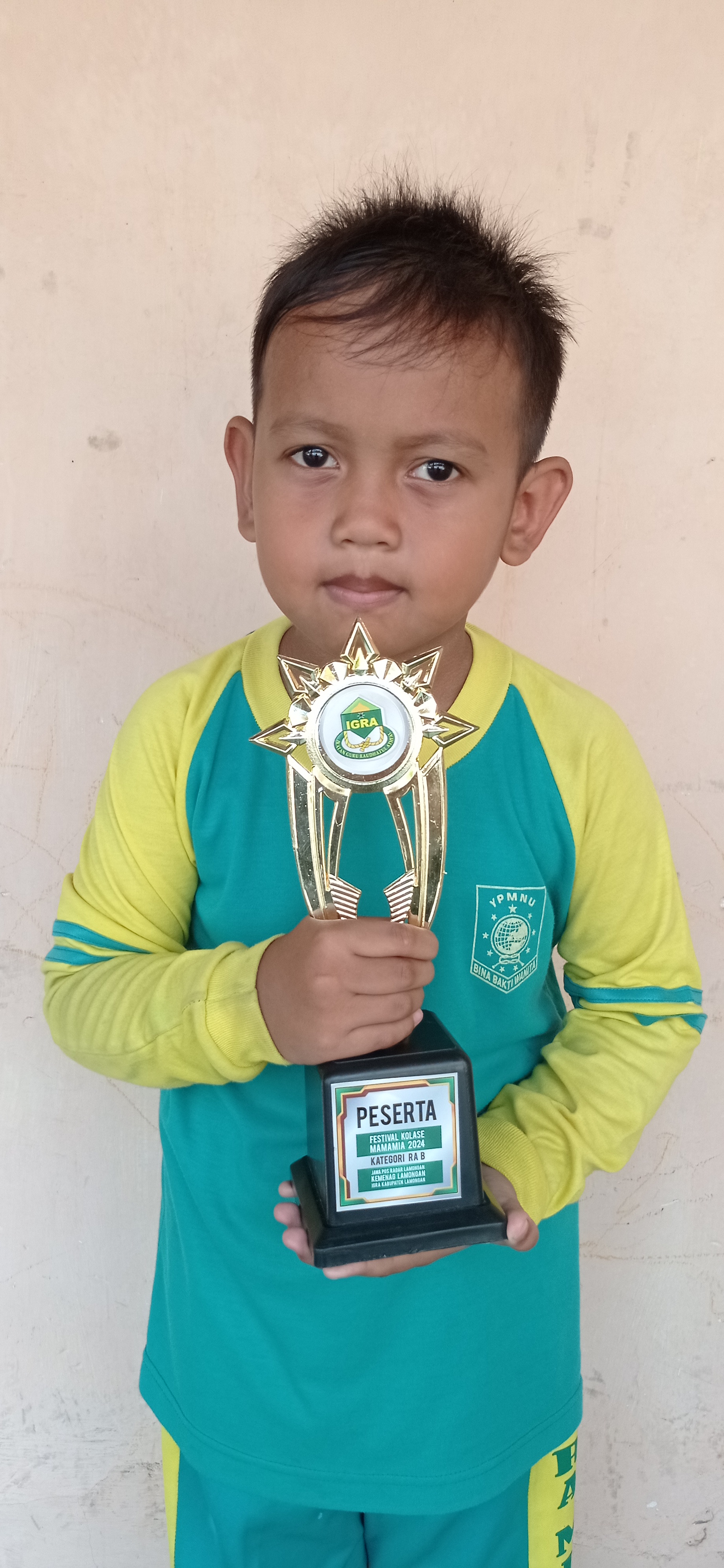 INGIN JADI PELUKIS: Al Abrisam Mahreen Achmad membawa piala finalis Festival Kolase Mamamia 2024. (ISTIMEWA/RADAR LAMONGAN)