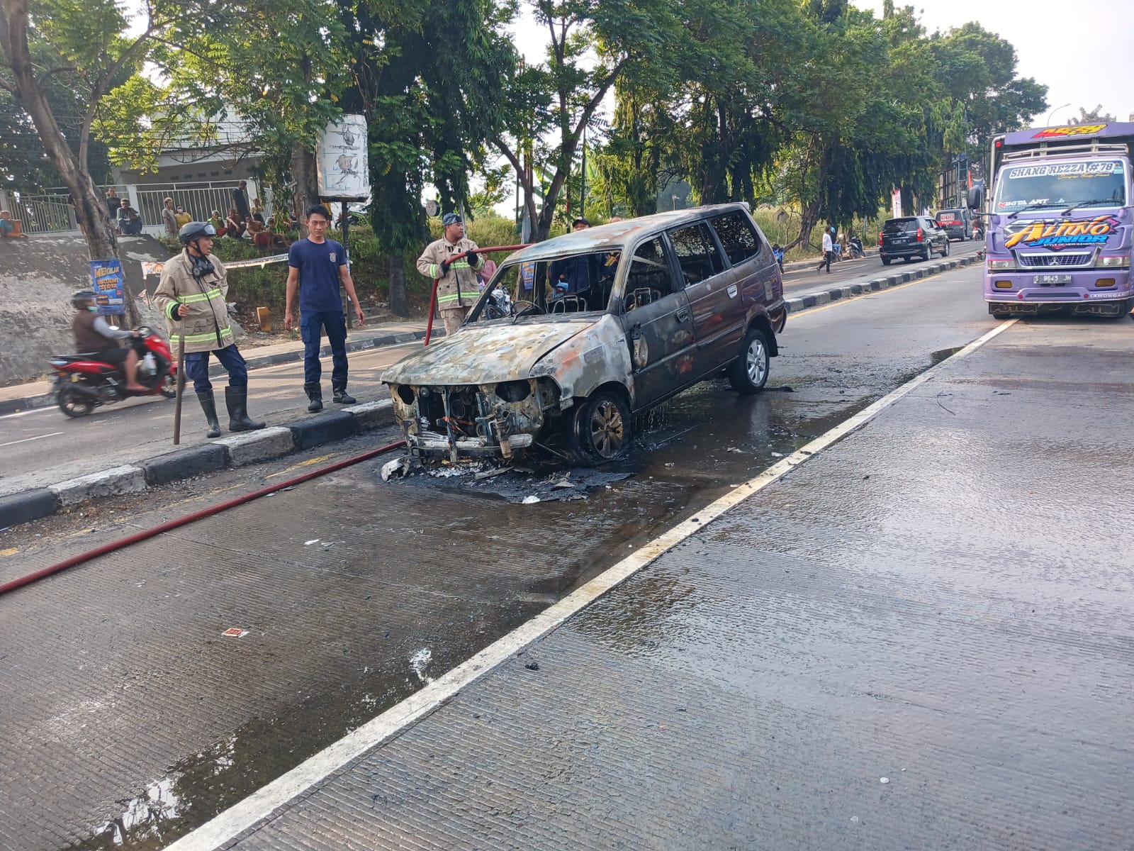 DIDUGA KONSLET : Minibus bernopol W 1386 TT milik warga Mojokerto terbakar di sekitar pertigaan RM. Mira Babat, Minggu (26/5) (istimewa. / Radar Lamongan)