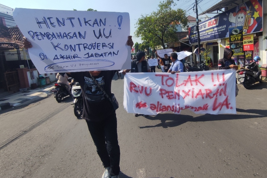 AKSI NYATA: Puluhan jurnalis yang tergabung dalam Aliansi Jurnalis Lamongan turun ke jalan dan membentangkan poster penolakan terhadap RUU Penyiaran.&nbsp;(Anjar D. Pradipta / Radar Lamongan)