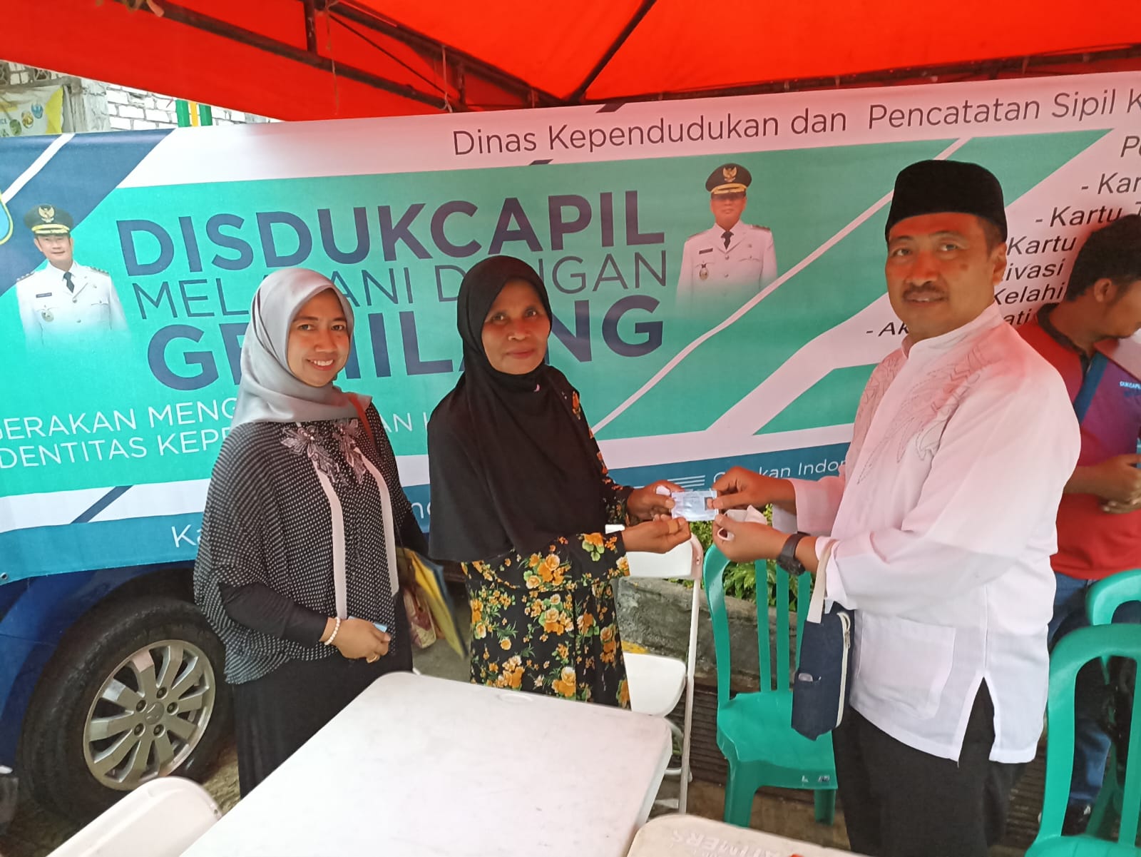PELAYANAN PRIMA: Kepala Dinas Kependudukan dan Pencatatan Sipil Lamongan, Achmad Edwyn Anedi, S.Sos menyerahkan KTP-el kepada salah satu masyarakat yang memanfaatkan program layanan keliling. (IST)
