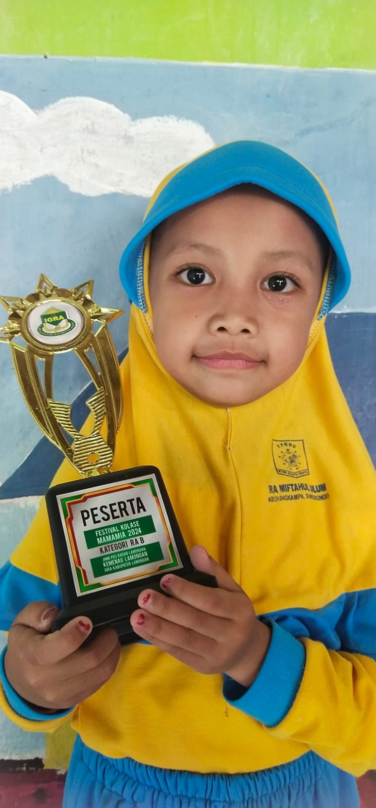 SUKA BUNGA: Ghonia Alfin Alya membawa piala finalis Festival Kolase Mamamia 2024. (ISTIMEWA/RADAR LAMONGAN)