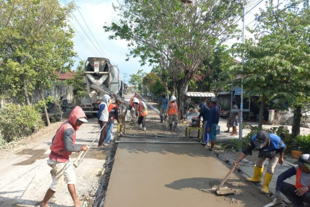 BERJALAN: Satu titik ruas jalan yang dalam proses pengecoran. Selanjutnya ada 12 titik ruas jalan lagi yang akan segera dikerjakan. (Ist. / Radar Lamongan)