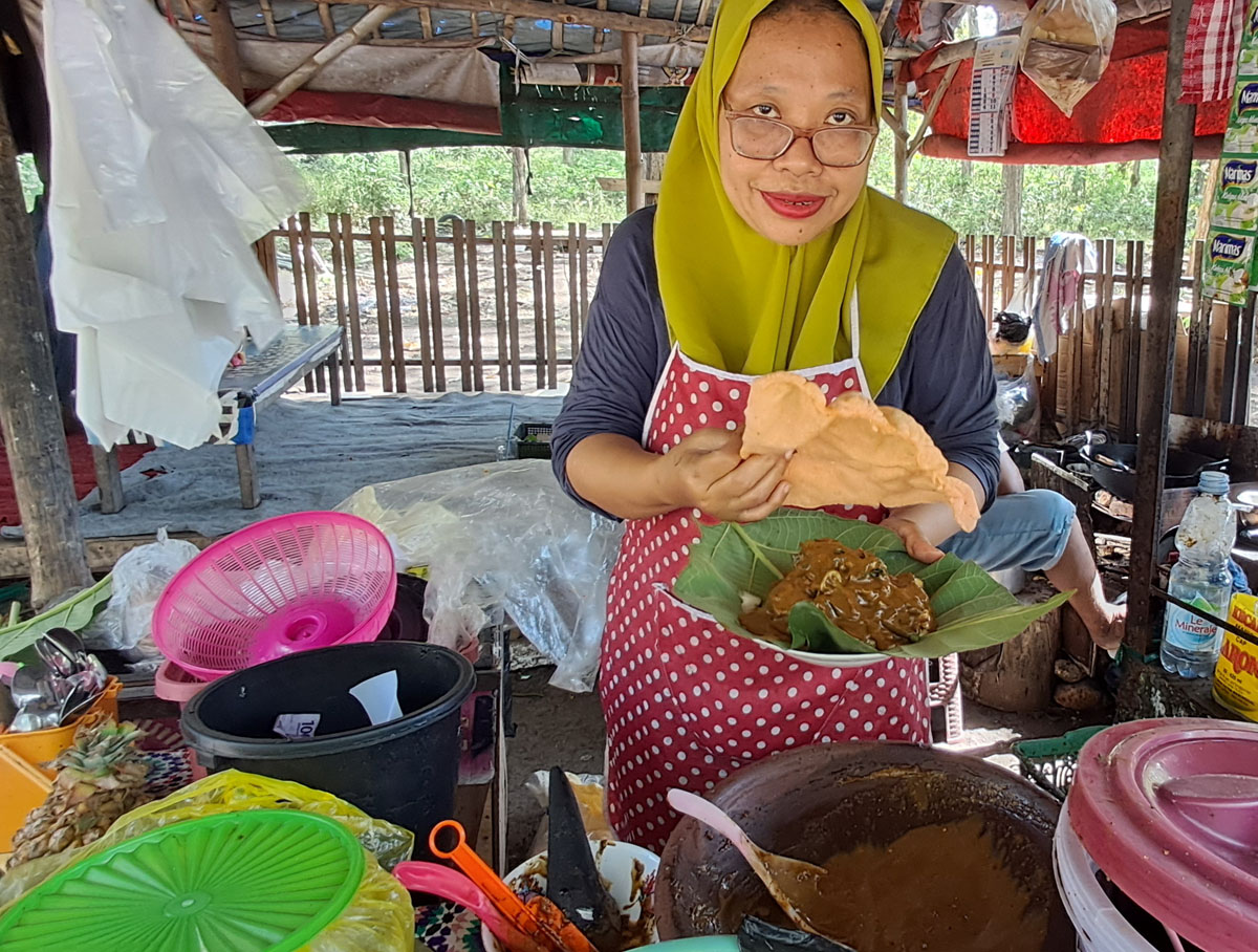 BUNGKUS DAUN JATI, KERUPUKNYA BESAR: Yanik menunjukkan rujak buatannya yang dijual di kawasan alas di Kecamatan Mantup. (GAMAL A/RDR.LMG)