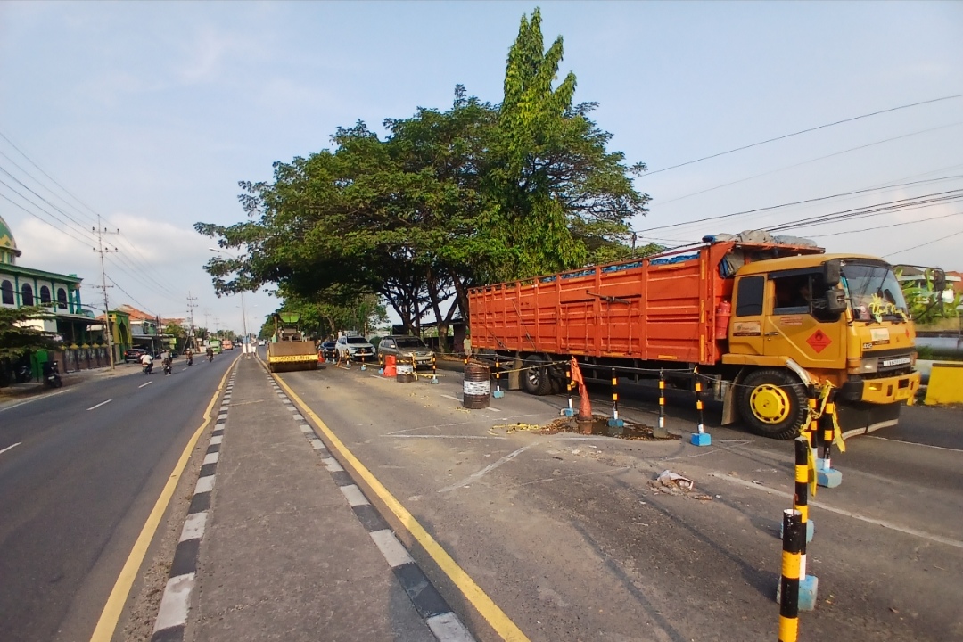 MULAI DIPERBAIKI: Titik jembatan Desa Surabayan di lajur selatan jalan nasional yang ambles diberi garis pembatas. (Anjar D. Pradipta / Radar Lamongan)