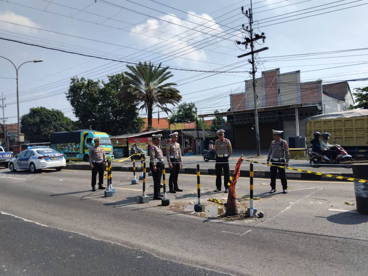 DIBERI TANDA: Satlantas Polres Lamongan mengecek titik kerusakan jembatan yang ambles. (IST/RDR.LMG)