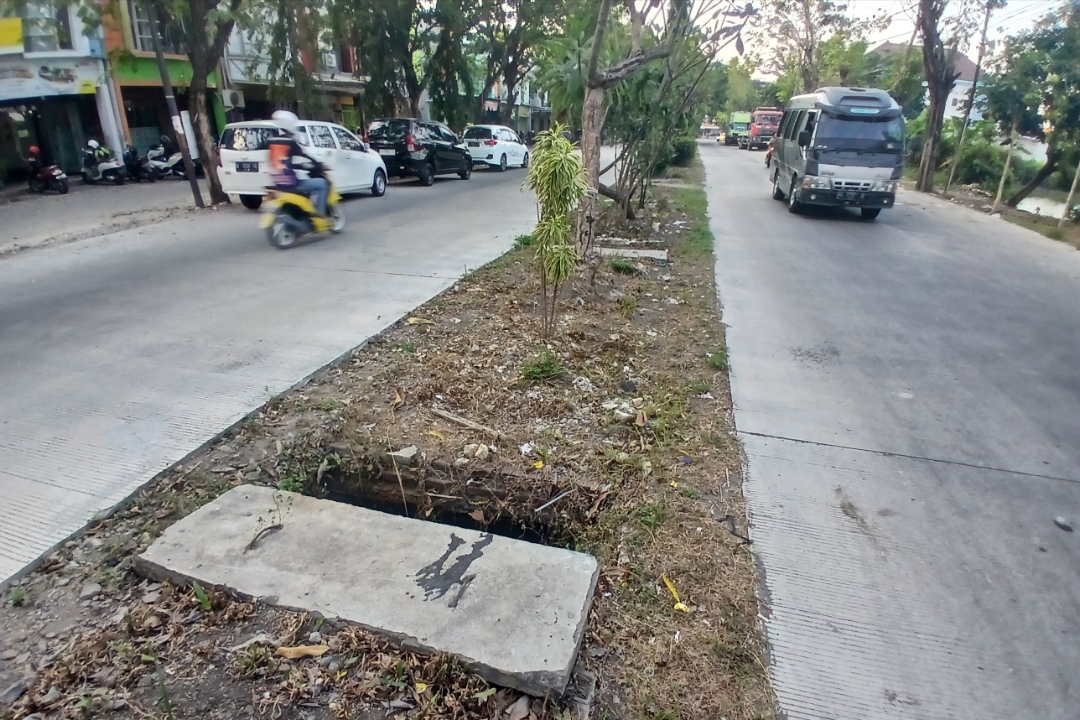 MEMBAHAYAKAN: Median jalan dan saluran drainase di Jalan Sunan Giri belum mendapatkan perbaikan.  (Anjar D. Pradipta / Radar Lamongan)