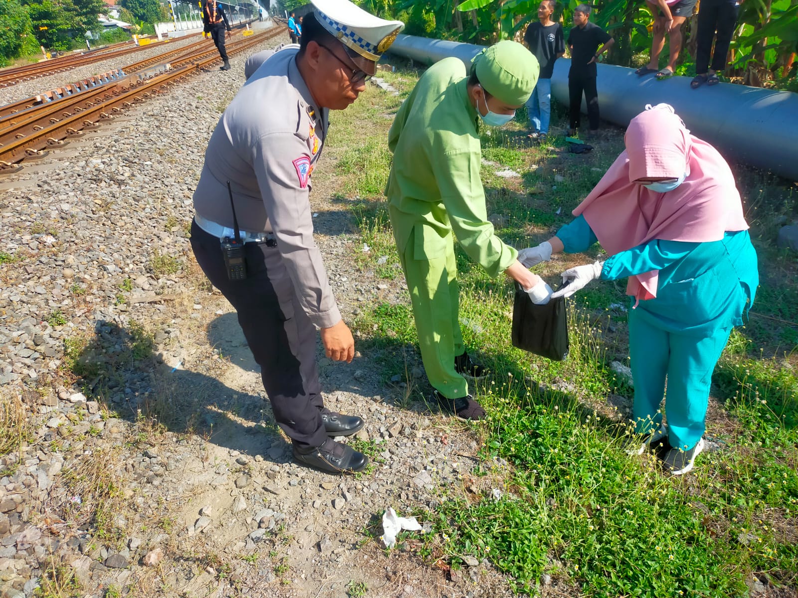 Polisi dan tenaga kesehatan mendatangi lokasi kejadian tertabraknya warga oleh kereta api jurusan Surabaya - Stasiun Gambir Jakarta. Korbannya meninggal dunia di tempat. (IST/RADAR LAMONGAN)