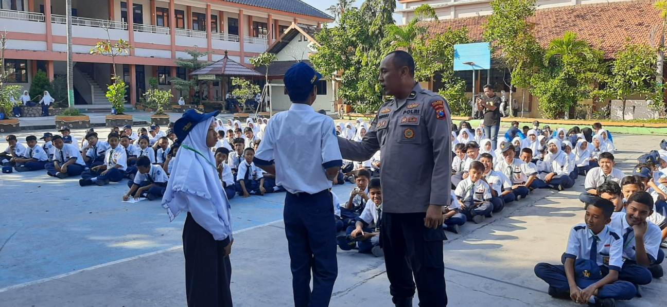 KOMUNIKASI DUA ARAH: Kanit Binpolmas Satbinmas Polres Lamongan, IPDA Purnomo, bersama siswa baru SMPN 4 Lamongan. (POLRES LAMONGAN/RDR.LMG)