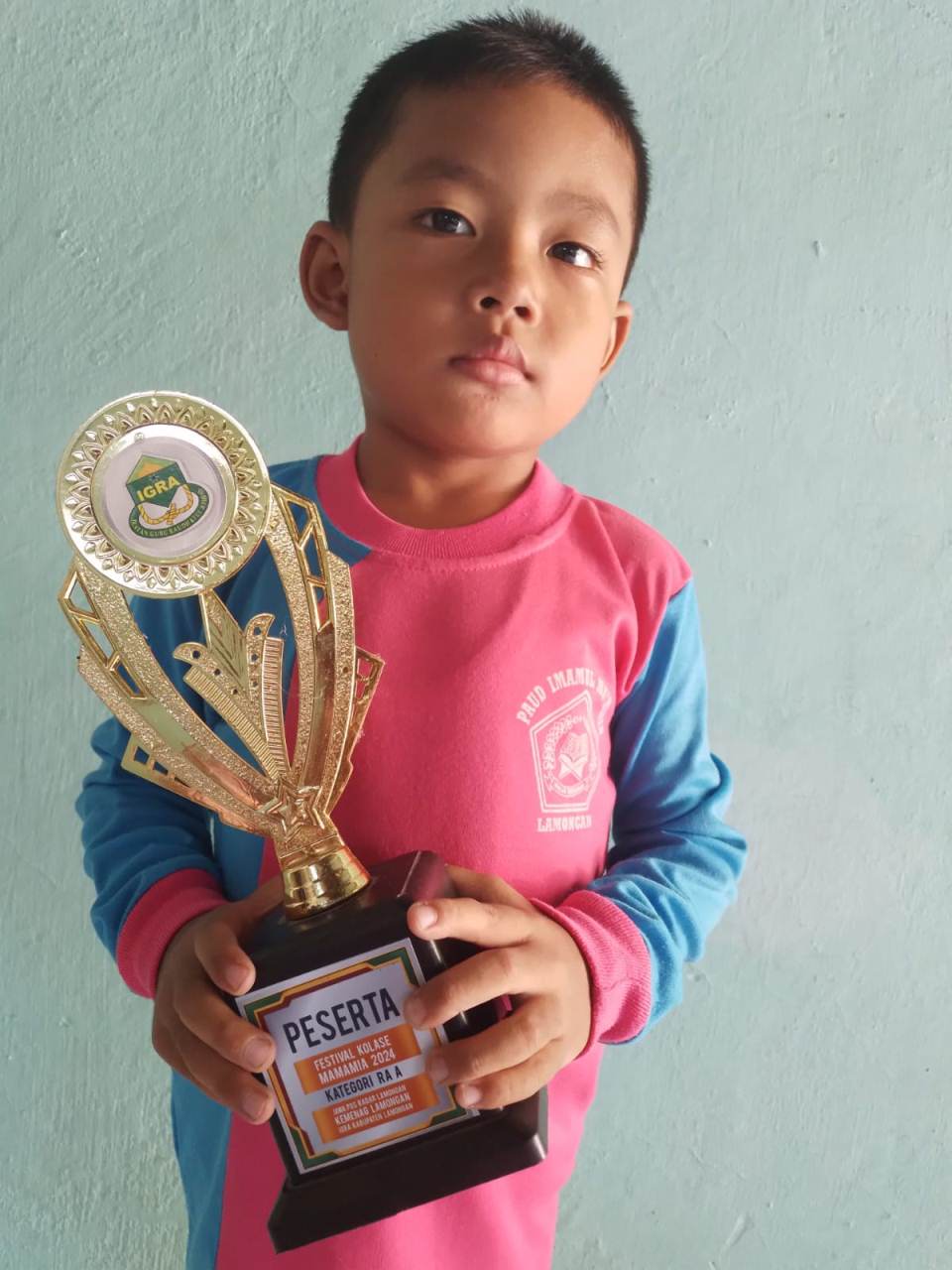 SUKA MEWARNAI: Ramadhanish Arvino Al Hafizh membawa piala finalis Festival Kolase Mamamia 2024. (IST/RDR.LMG)