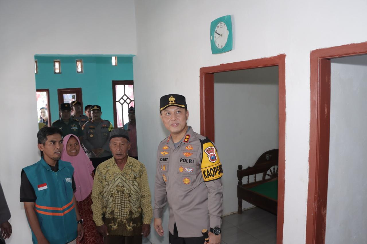 KADO HARI BHAYANGKARI BAGI WARGA KURANG MAMPU: Kapolres AKBP Bobby A Condroputra mengajak Samirun, warga Desa Nguwok, Modo, melihat  bagian rumahnya yang sudah diperbaiki. (GAMAL A/RDR.LMG)