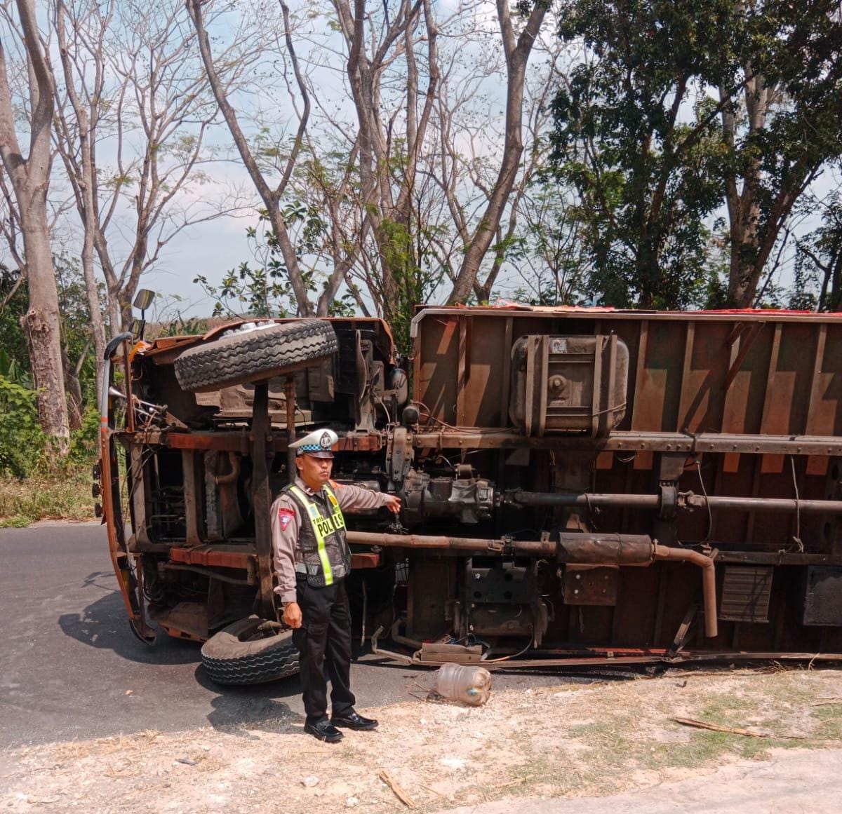 TERGULING: Truk E 9407 E yang bermuatan popok terguling di jalan raya masuk Desa Girik, Kecamatan Ngimbang. (IST/RADAR LAMONGAN)
