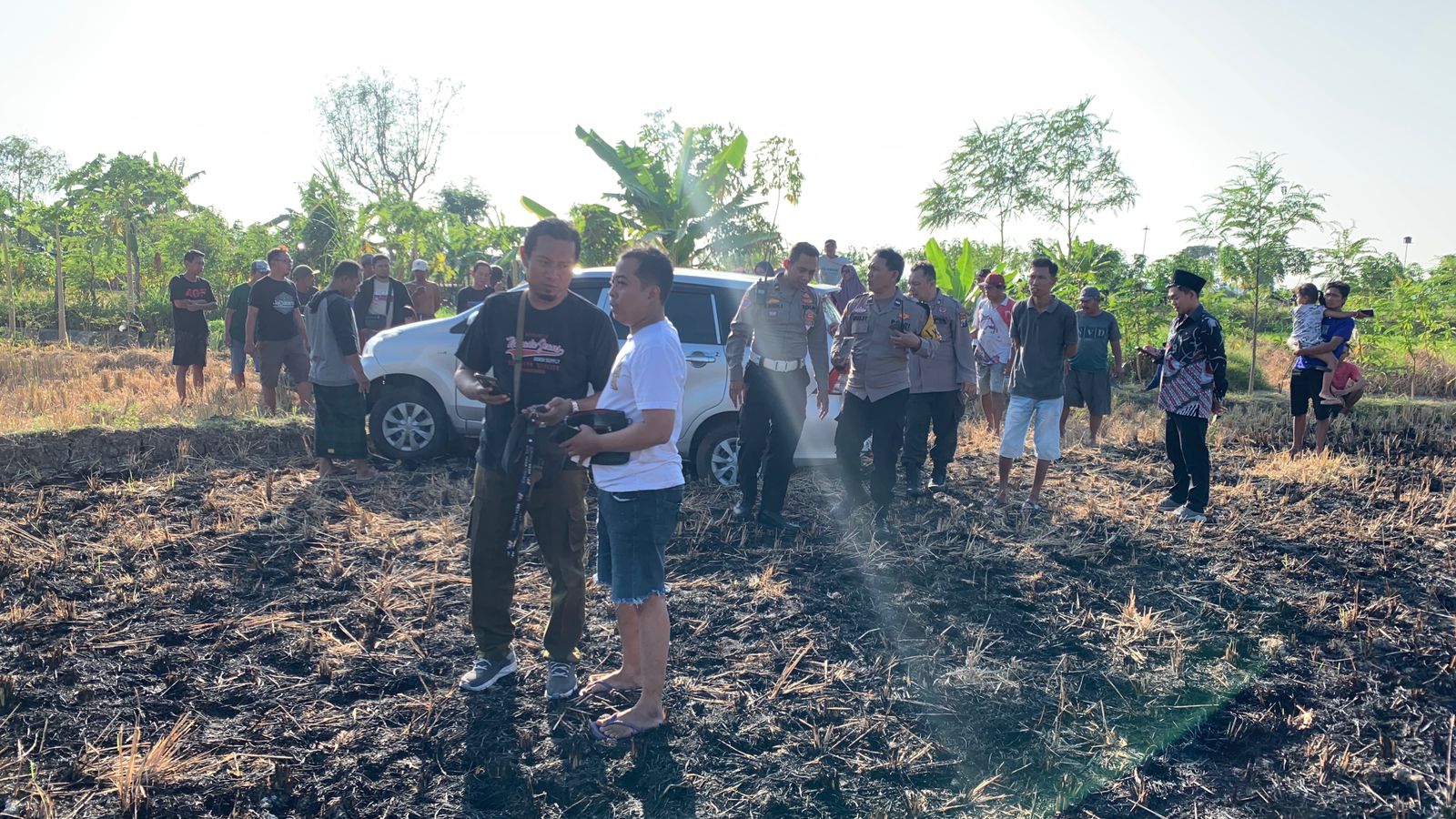 Mobil berwarna silver tersebut berada di tengah sawah dekat waduk di desa setempat. (Ist. / Radar Lamongan)