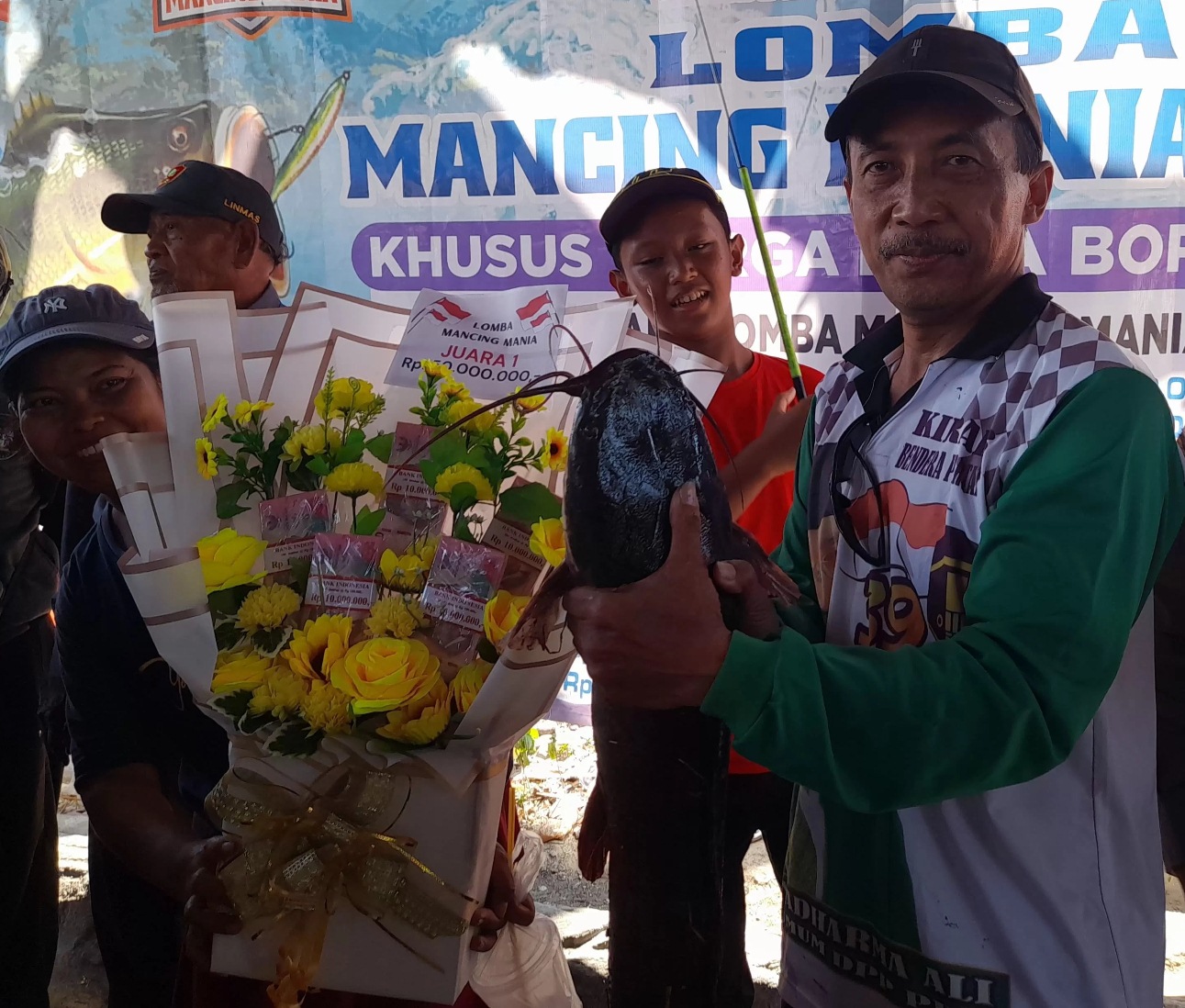 JUMBO : Hari Purnomo menunjukkan lele seberat 5 kg hasil  pancingannya yang dinyatakan sebagai pemenang. (M SAIFUL ROHMAN/RADAR SIDOARJO)