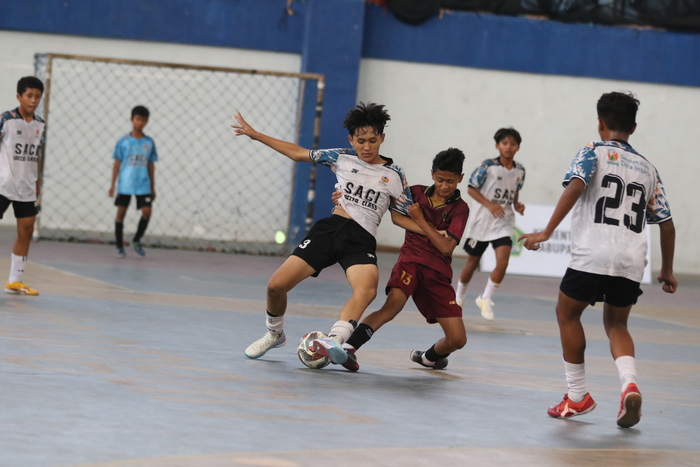 SENGIT : Pemain SMPN 1 Lamongan (kaos merah) berusaha merebut bola dari pemain SACI. (Anjar/Radar Lamongan)