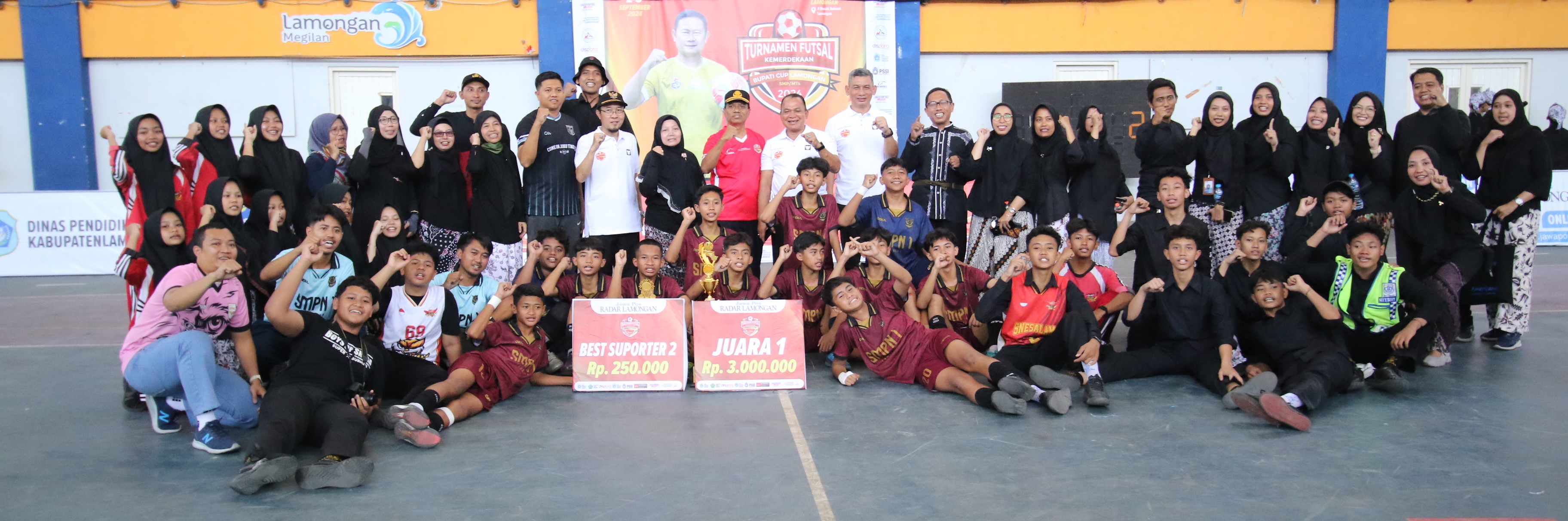 SKUAD JUARA : Sekda Lamongan Moh Nalikan, Kepala Dinas Pendidikan Munif Syarif, dan Direktur Jawa Pos Radar Bojonegoro Bachtiar Febrianto diajak foto bersama pemain SMPN 1 Lamongan. (Jar/Rdr.lmg)