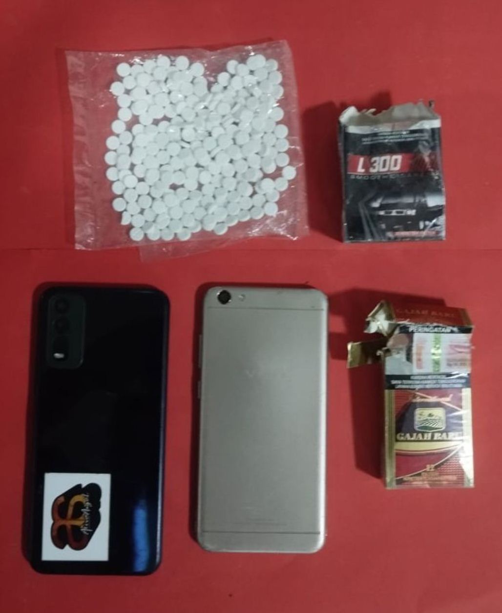 BARANG BUKTI: HP dan pil dobel L yang diamankan Satreskoba Polres Lamongan. (IST/RDR.LMG)