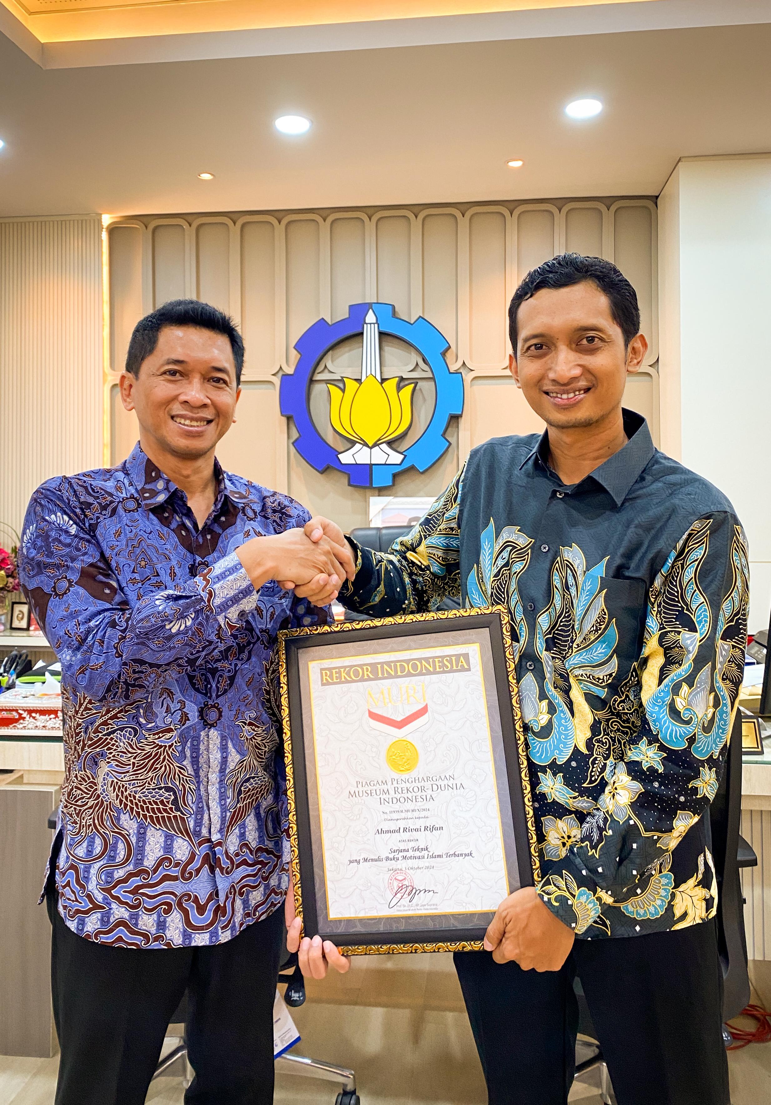 MENEBAR MANFAAT : Penulis Ahmad Rifai Rifan (kanan) menerima ucapan selamat atas pencapaian MURI dari Rektor ITS Bambang Pramujati, S.T., M.Sc.Eng., Ph.D.,. (IST/RADAR LAMONGAN)