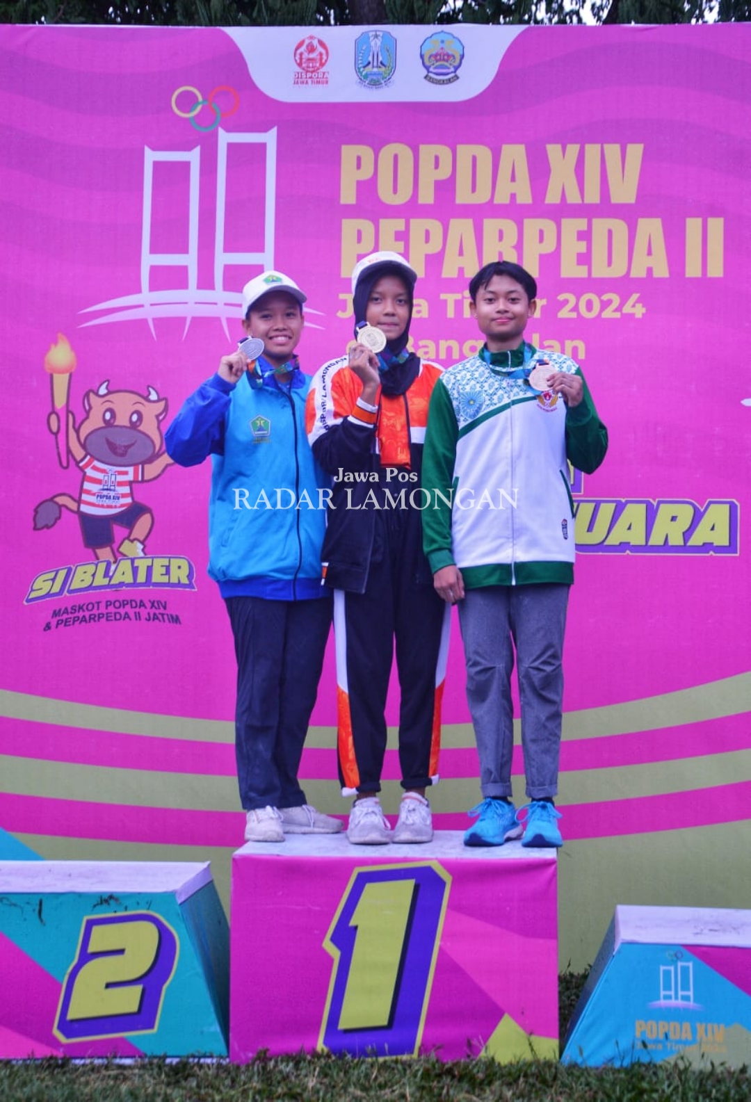 BERPRESTASI: Anggita Dinar Ibnu Oktavy (tengah) menunjukkan medali emas yang diraihnya di cabor panjang tebing.  (IST/RADAR LAMONGAN)