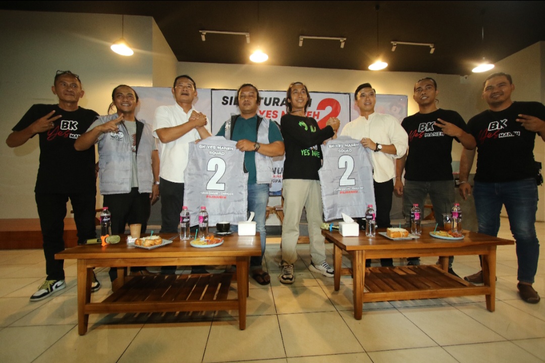 KOMITMEN BERSAMA: Relawan BK Yes Maneh menyerahkan rompi kepada paslon Yes-Dirham.