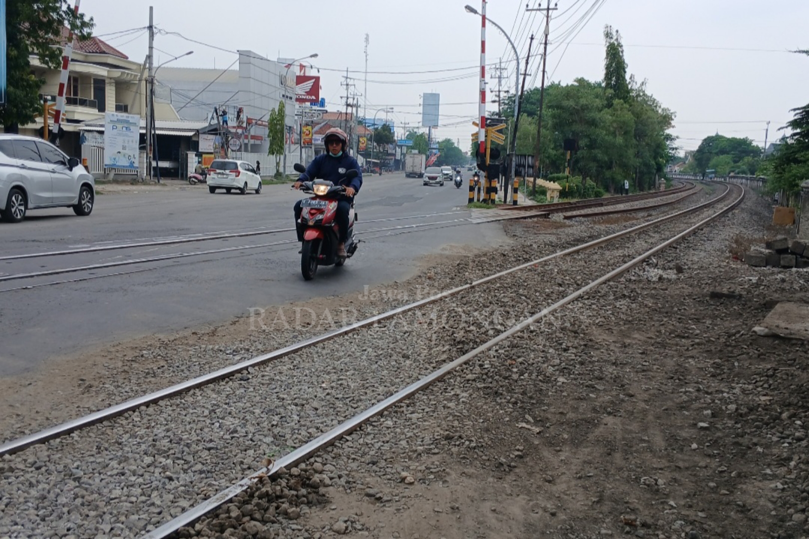 Saat siang hari arus lalin di perintasan KA jalan nasional lancar, tapi saat malam hingga pagi hari pengendara jalan bakal terkendala adanya perbaikan. (Anjar D. Pradipta / Radar Lamongan)