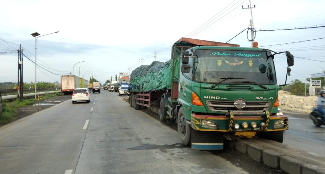 MUATAN DIEVAKUASI: Truk S 8850 US yang bermuatan pupuk naik di median jalan. (GAMAL A/RDR.LMG)
